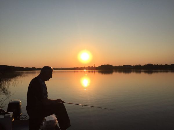 Angeln im Emsland – Mann beim Angeln an der Ems im Sonnenuntergang (Ems)