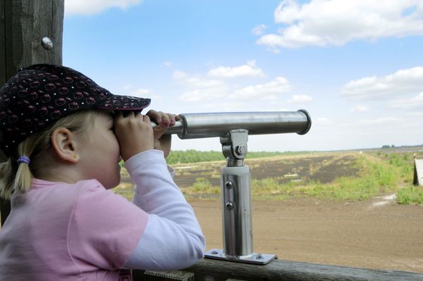 Erlebnispfad "moor-land-schaffen" - Mädchen blickt vom Aussichtsturm auf Moorlandschaft