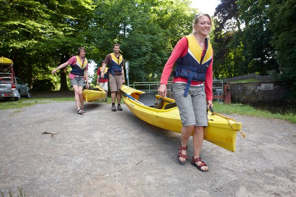 Paddeln auf Ems und Hase - Kanus werden zum Bootsanleger getragen 