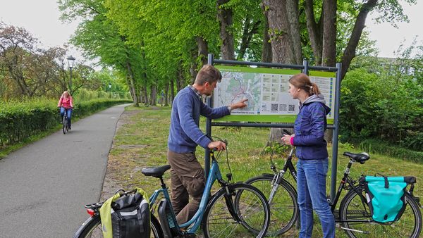 Radfahrer vor Infotafel vom Fahrradknotennetz Emsland am Dortmund-Ems-Kanal in Meppen