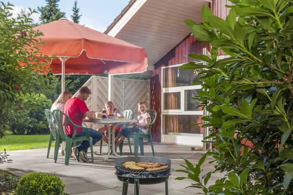 Familie beim Grillen auf der Terrasse vom Ferienhaus im Emsland-Urlaub 