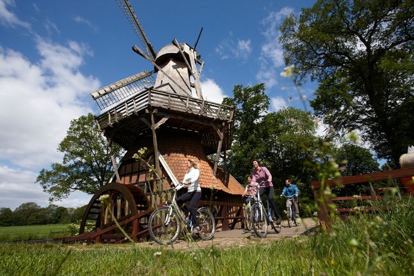 Hüvener Mühle - Radfahrer passieren die Mühle auf der Radtour entlang der Emsland-Route 