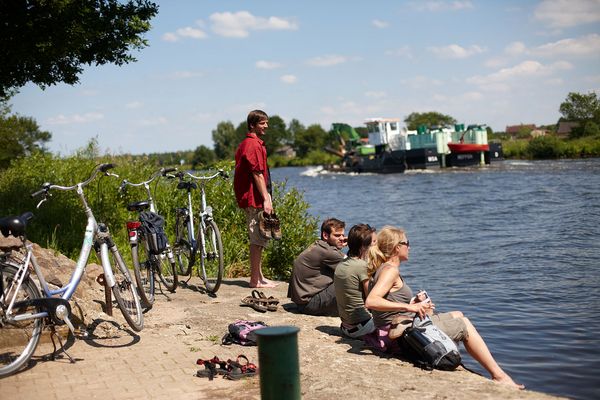 Radfahrer unterwegs auf der Emsland-Route pausieren an der Ems